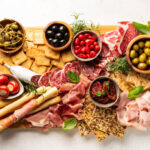 cheese board with cheese fruit nuts meat.