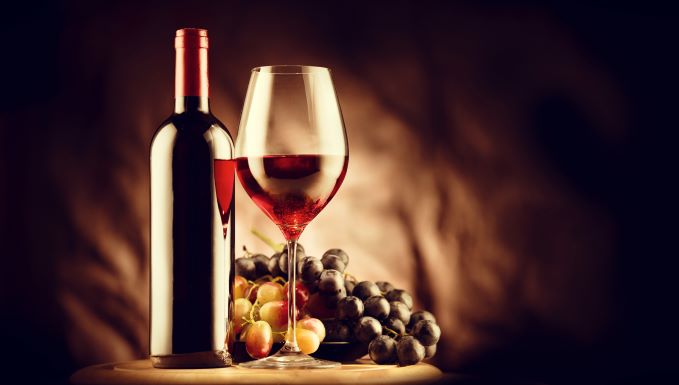 wine and glass with red and white grapes